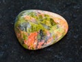 polished Unakite gemstone on dark background