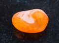 tumbled Carnelian gemstone on dark background