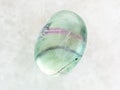 tumbled Fluorite gemstone on white marble