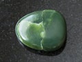 tumbled green nephrite gemstone on dark