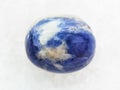 tumbled Sodalite gem stone on white marble Royalty Free Stock Photo