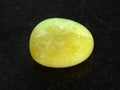 tumbled yellow calcite gemstone on dark