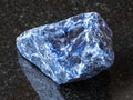 Raw Sodalite gemstone on black granite Royalty Free Stock Photo