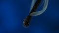 Macro shot of a black charred match and clouds of white smoke. Burned extinguished wooden match on dark studio