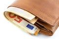 A macro shot of a brown mens leather wallet with a stack of Euro banknotes inside, isolated on a white background, visible 50 Eur