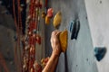 Macro shot of climbers hands gripping colourful handholds during indoor workout