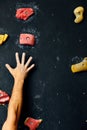 Macro shot of climbers hands gripping colourful handholds during indoor workout