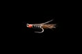 Macro shot colorful fishing fly isolated on a black background. Hand made fly fishing flies. Fluffy fly fishing hook isolated Royalty Free Stock Photo