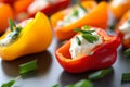 Macro shot of colorful stuffed mini sweet peppers filled with tangy cream cheese and topped with fresh chives