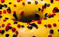 Macro shot of donut or doughnut with yellow frosting covered by black and red sprinkles topping