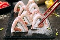 Macro Shot of Eating Bacon Uramaki Sushi Rolls in Restaurant Closeup