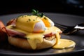 Macro shot of Eggs Benedict with a runny yolk oozing out of the perfectly poached egg and mixing with the hollandaise sauce