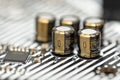 A macro shot of five capacitors in a metal housing, soldered to the motherboard of a desktop computer. Royalty Free Stock Photo