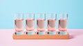 Macro shot of five glass test tubes with pink liquid on light blue backdrop, symbolizing scientific exploration and analysis Royalty Free Stock Photo