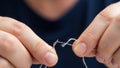 Close-up of hands threading white thread through a needle. Royalty Free Stock Photo
