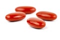 A macro shot of four red film-coated tablets arranged randomly, isolated on a white background. Royalty Free Stock Photo