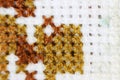Macro shot fragment embroidery pattern brown thread handmade embroidery, pattern in cross-stitch style on white fabric