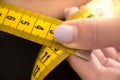 Macro shot Girl measures her waist. measuring tape measure concept Royalty Free Stock Photo