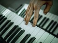 Macro shot hand playing on the synthesizer piano keys