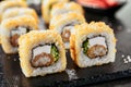 Macro shot of hot crispy ebi tempura maki sushi rolls with cream cheese, king prawn, chuka kelp salad and nori. Deep fried uramaki Royalty Free Stock Photo