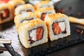 Macro shot of hot crispy tempura maki sushi rolls with cream cheese, raw salmon, tomato and nori seaweed. Deep fried uramaki roll Royalty Free Stock Photo