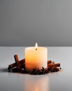 Macro shot of a lit candle surrounded by cinnamon sticks and star anise Royalty Free Stock Photo