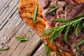 Macro shot of medium rare grilled juicy beef steak ribeye with rosemary on wooden cutting board on dark blue background. Royalty Free Stock Photo