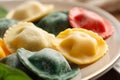 Macro shot of a plate of colorful ravioli pasta stuffed with spinach and ricotta cheese