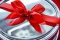 macro shot of red ribbon bow on shiny silver gift box lid Royalty Free Stock Photo