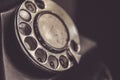 Macro shot rotary dial on grungy, old telephone phone
