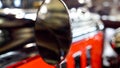Macro shot of round back view mirror on vintage car painted in red and black Royalty Free Stock Photo