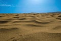 Macro shot of sand surface against blue sky background with small clouds and sun halo. Unique natural areas such as Royalty Free Stock Photo