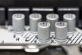 A macro shot of six capacitors in a metal housing, soldered to the motherboard of a desktop computer. Royalty Free Stock Photo