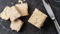 macro shot of sliced halva and silver knife on black marble surface top view