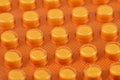 Macro shot of small pills in yellow plasticc package