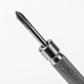 Macro Shot of a Small Silver Screwdriver with Textured Grip Against White Backdrop Royalty Free Stock Photo