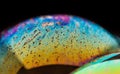 Macro shot of a soap bubble with a bright-colored texture isolated against a black background Royalty Free Stock Photo