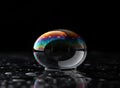 Macro Shot of Soap Bubble with Iridescent Rainbow Patterns on Dark Reflective Surface Royalty Free Stock Photo