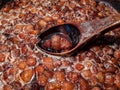 Macro shot of strawberries boiling in dark pot. Cooking homemade strawberry jam in a pot stirring with wooden spoon Royalty Free Stock Photo