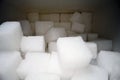 Macro shot of sugar cubes next to carton box on wooden table. Unhealthy food sweetener, sweet crystal cubes Royalty Free Stock Photo