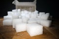 Macro shot of sugar cubes next to carton box on wooden table. Unhealthy food sweetener, sweet crystal cubes Royalty Free Stock Photo