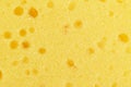 Macro shot of a surface of plastic yellow sponge. Close-up texture. Macro shot of a yellow scrub sponge. Sponge texture background Royalty Free Stock Photo