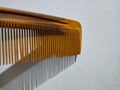 Macro shot of a tan comb casting dramatic, long shadows against a stark white wall Royalty Free Stock Photo