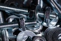 A Macro shot of the Threads of a small stainless steel bolt on a pile of washers, nuts and bolts.  High Contrast Royalty Free Stock Photo