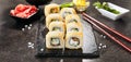 Macro shot of unagi tempura uramaki sushi rolls with rice, cream cheese, eel, cucumber and nori. Hot crispy maki roll on black sto Royalty Free Stock Photo