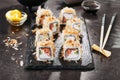 Macro shot of uramaki sushi rolls with cream cheese, salmon, tuna shavings or dried bonito, cucumber, nori. Portion of fresh katsu