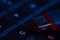 Macro shot of USB flash drive on a laptop keyboard with neon lights. Concept of modern IT technology. Information storage device Royalty Free Stock Photo