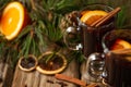 Macro shot view of appetizing christmas composition glasses of mulled wine on spruce cone and branch background. fragrant spices.