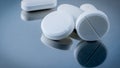 Macro shot of white tablet pills on silver background with shadows. Antacids pills for relief stomachache from excess gastric aci