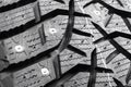 Macro shot winter studded tire. Winter car tires isolated on black background. Tyre protector close up. Square powerful spikes.